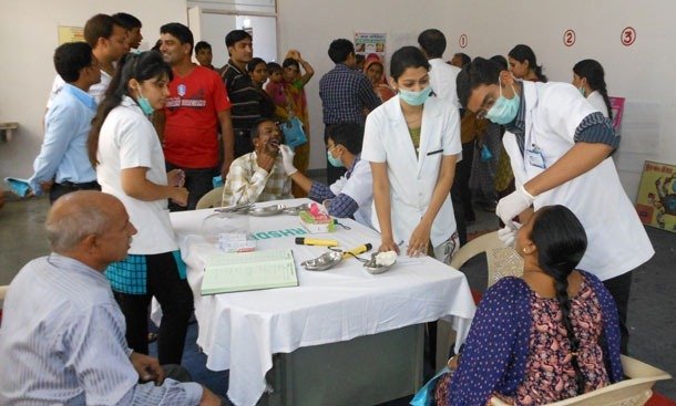 Clinicians and volunteers attending to residents at a Macsys Life Science health camp